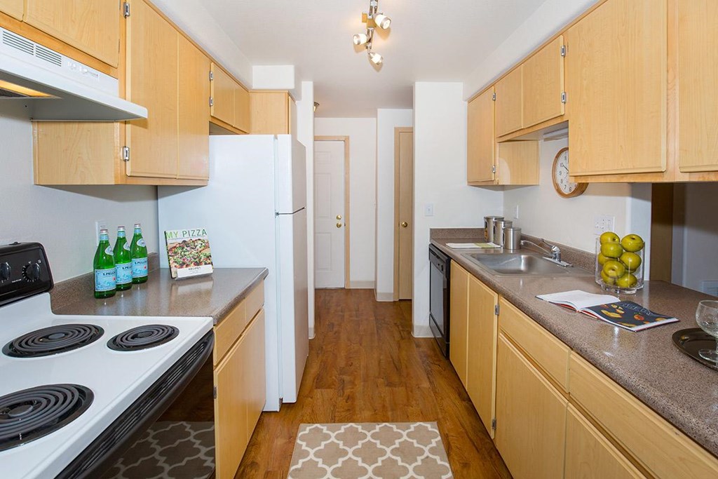 a kitchen with wooden cabinets and a stove and a sink